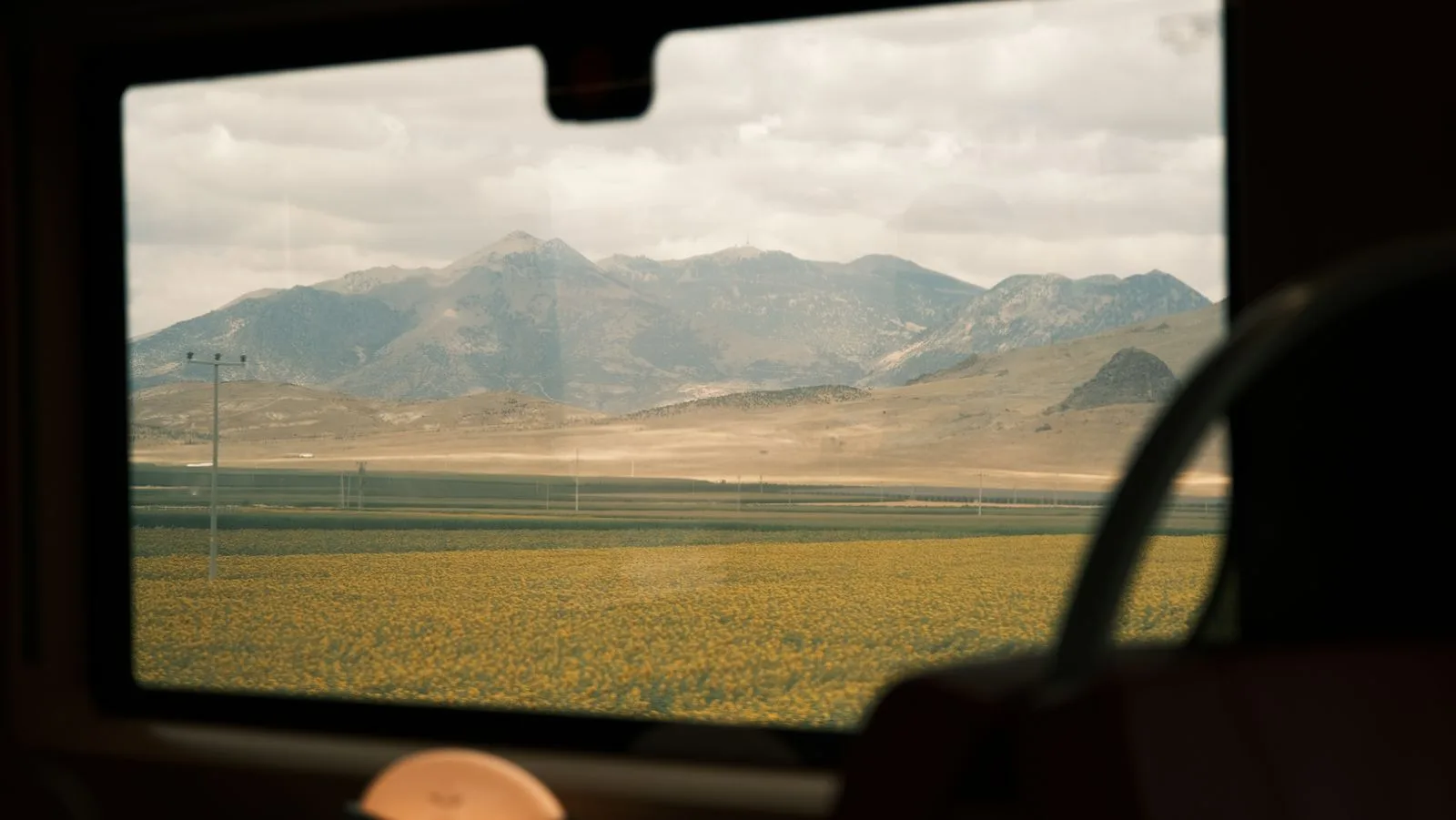 Fields and distant mountains seen through a train window
